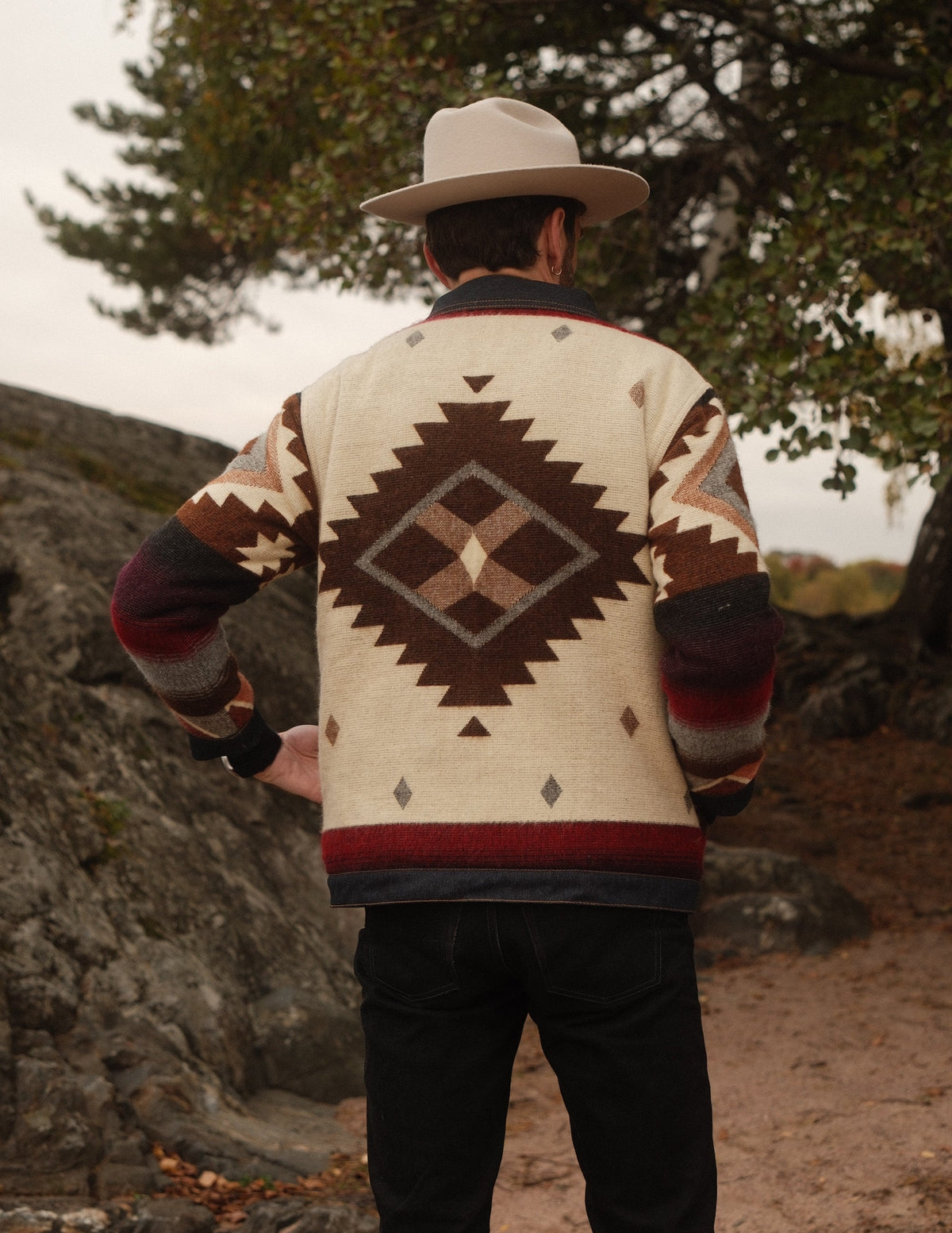 Back view of the Peguche Jacket, cream wool with a brown Andean diamond, outdoors at dusk