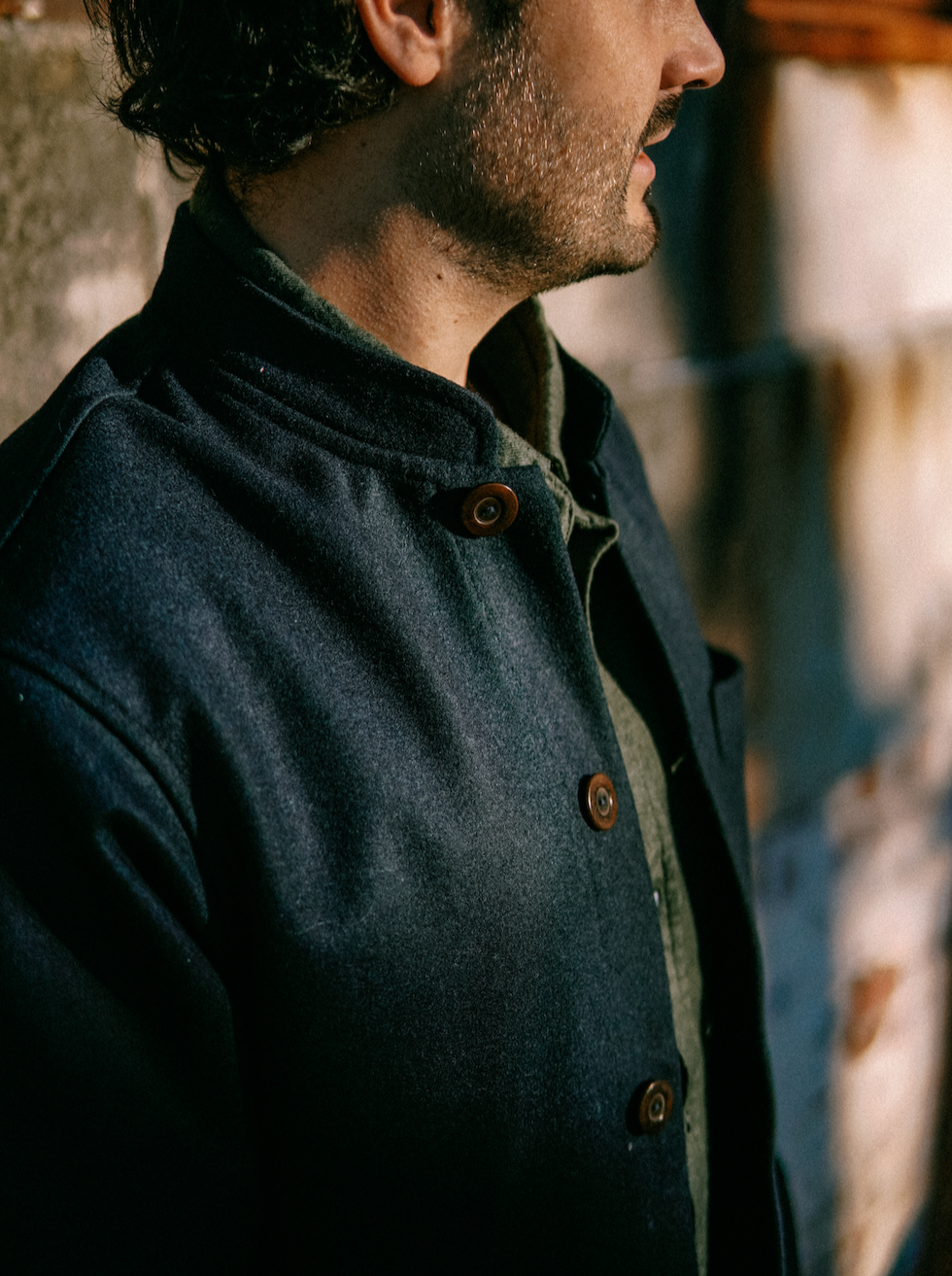 Side view of the Tambo Wool Jacket in Navy, buttoned, in warm afternoon light